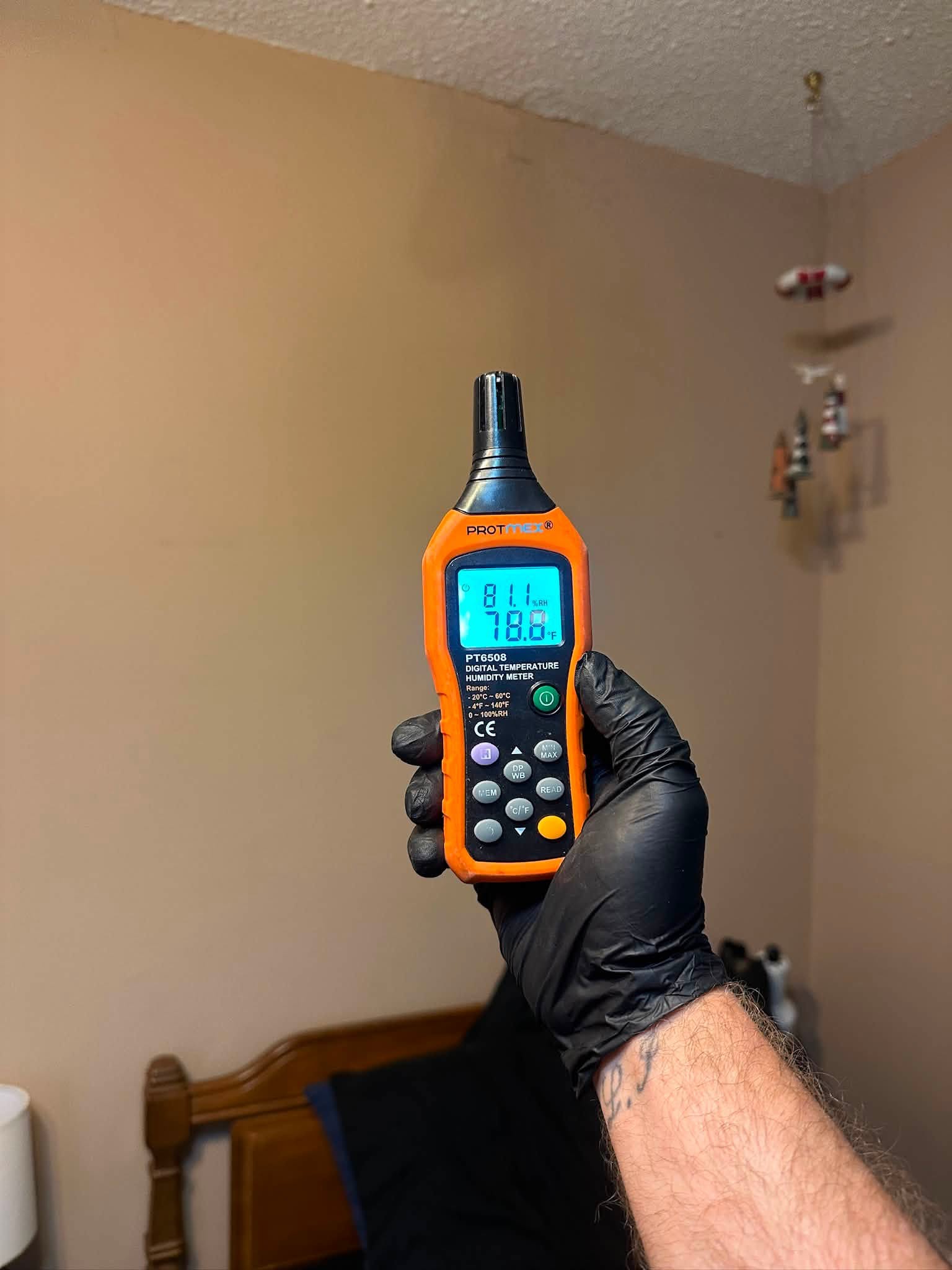 Technician holding a humidity and temperature meter during a water damage inspection in Bellingham, WA