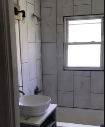 Renovated bathroom with tiled shower and vanity sink after water damage repair in Bellingham, Washington