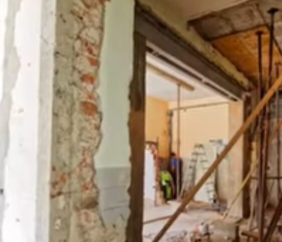 Exposed brick and structural framing during fire and water damage wall reconstruction in a Bellingham home.